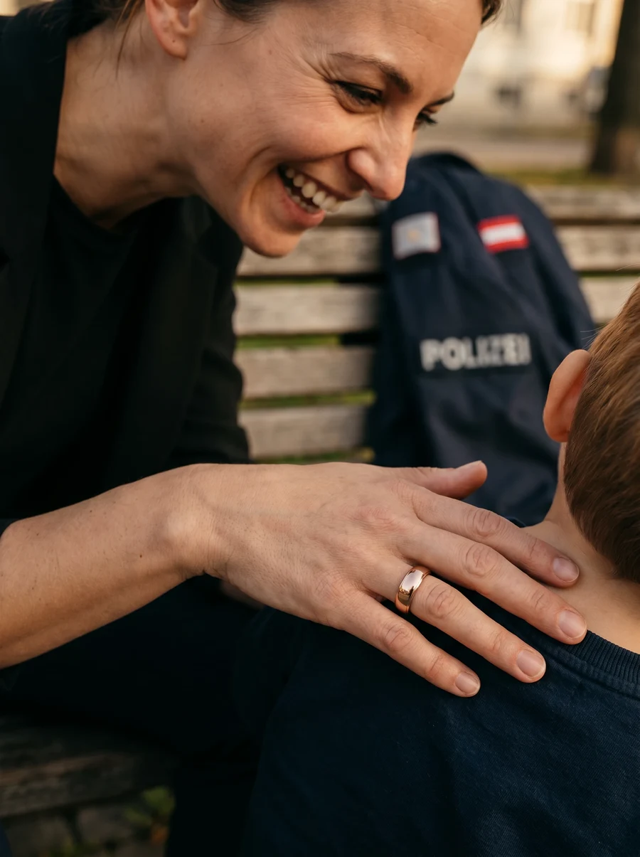 Polizistin in Zivil mit ihrem Kind am Spielplatz, Dienstjacke auf der Bank